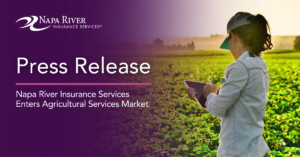 Female farmer holding a tablet in a crop field.