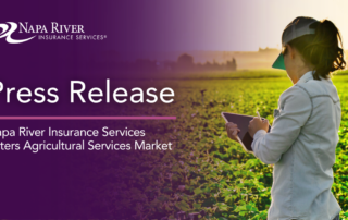 Female farmer holding a tablet in a crop field.